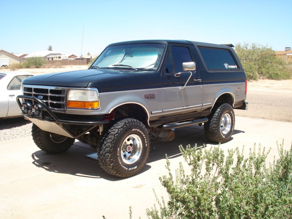 1994 Ford Bronco with aftermarket bumper and lift kit, parked outdoors