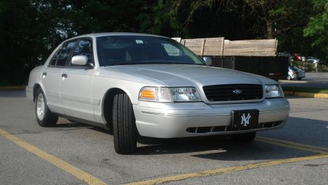 2000 Ford Crown Victoria - A silver 2000 Ford Crown Victoria is seen from the front-right angle, parked outdoors.