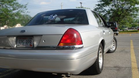 2000 Ford Crown Victoria - Rear view of a silver sedan, possibly a Ford Crown Victoria, with its taillights visible.