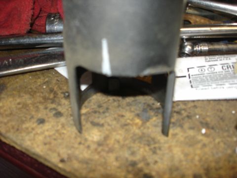 1979 Ford F-250 - A close-up view of an exhaust pipe positioned above a bed of wood chips.