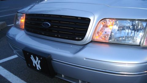 2000 Ford Crown Victoria - The front of a silver 2000 Ford Crown Victoria is shown, its grille and headlights.
