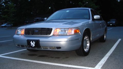 2000 Ford Crown Victoria - A silver 2000 Ford Crown Victoria is parked in a lot, a black grille and a New York Yankees license plate frame.