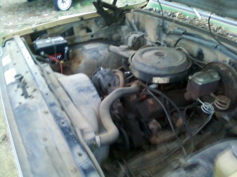 2006 Ford E350 - The engine bay of an older vehicle, showing the battery, air cleaner, and various hoses and components.