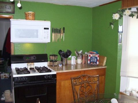 2006 Ford E350 - Interior view of a kitchen a microwave, gas range, and various kitchenware on the countertop.