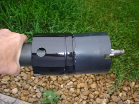 1979 Ford F-250 - A black steering column shroud is held by a hand, with a metal shaft visible at the end.