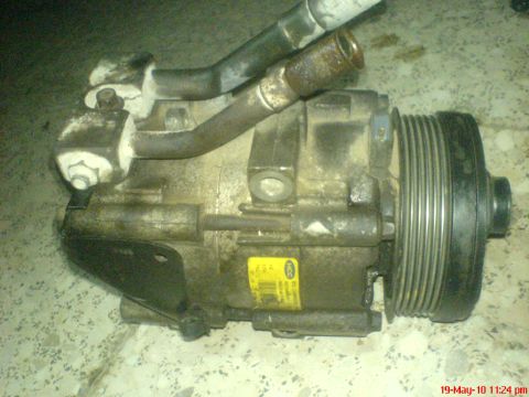 1998 Ford Crown Victoria - A dirty A/C compressor with a yellow label is shown, likely a replacement part.