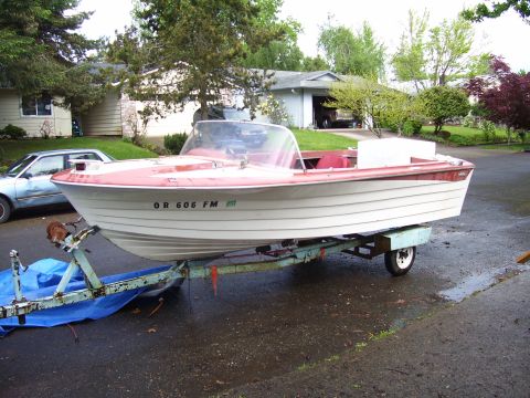 1979 Ford Bronco - A white and red boat is parked on a trailer in a driveway.