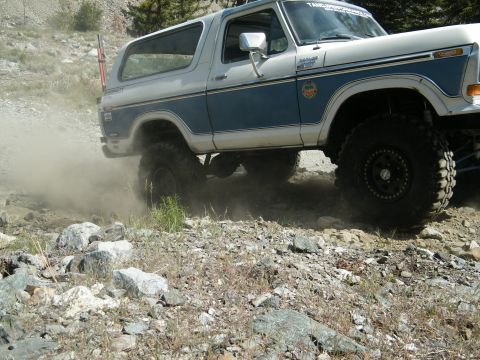 1982 Ford Bronco - This 1980 Ford Bronco navigates a dusty, rocky off-road path, its lifted suspension and capabilities.
