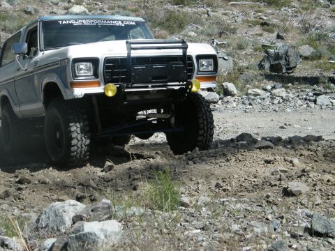 1982 Ford Bronco - Ford Bronco navigates a rocky, off-road trail in a desert-like environment.