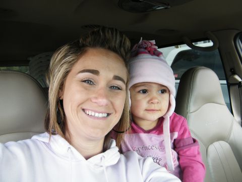 1982 Ford Bronco - A woman and a baby girl wearing a pink hat are inside a vehicle.