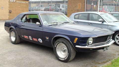 1970 Ford Mustang - A classic 1970 Ford Mustang is parked outdoors, showing off its iconic design and racing heritage.
