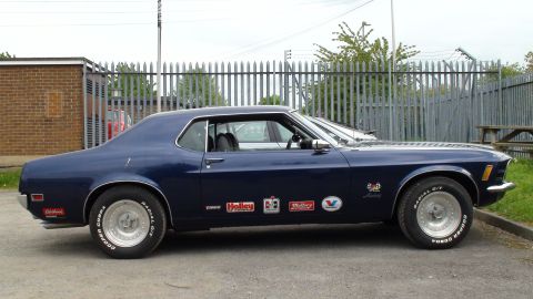1970 Ford Mustang - Side profile of a 1970 Ford Mustang coupe with various racing decals applied to the doors.