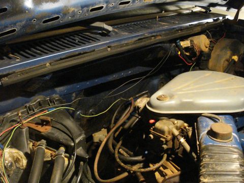 1985 Ford F-150 - The engine bay shows a complex network of wires and hoses, with a carburetor and air cleaner visible.