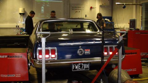 1970 Ford Mustang - A blue 1970 Ford Mustang is positioned on a dynamometer in a workshop setting.