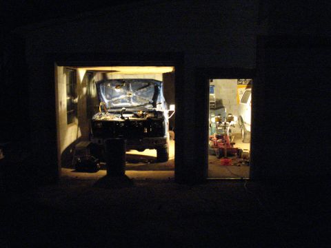 1985 Ford F-150 - A blue truck is parked in a garage with its hood open, and another vehicle is visible in the background.