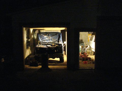 1985 Ford F-150 - A blue truck sits in a garage with its hood open, while a white vehicle is parked in the next bay.