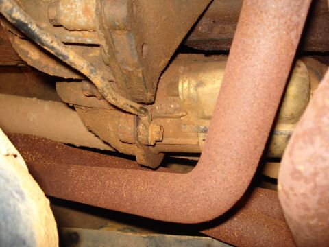 1985 Ford F-150 - Close-up view of the undercarriage, showing rusty exhaust pipes and suspension components.