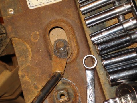 1985 Ford F-150 - Rusty bracket with wiring and tools, likely from a vehicle repair.