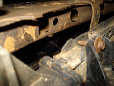1985 Ford F-150 - A close-up view shows a wiring harness secured with zip ties, partially obscured by rusty metal framing.
