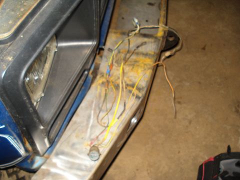 1985 Ford F-150 - Exposed electrical wires are visible on the front of a vehicle, suggesting a repair or modification is underway.