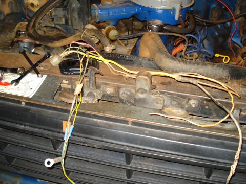 1985 Ford F-150 - Close-up of engine bay wiring and components, showing a blue engine block and various hoses.