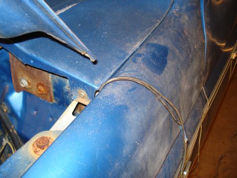 1985 Ford F-150 - Close-up view of the blue fender and wiring on a 1985 Ford F-150, showing some rust on the mounting bracket.