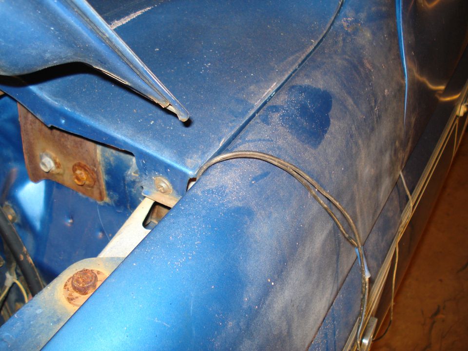 Blue fender with visible wiring and rust on mounting bracket. 1985 Ford F-150