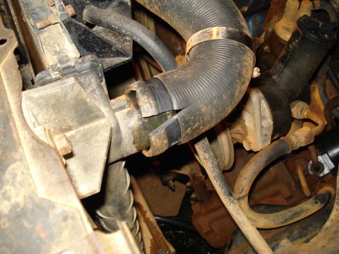 1985 Ford F-150 - Close-up view of the radiator hose connection within the engine compartment of a 1985 Ford F-150.