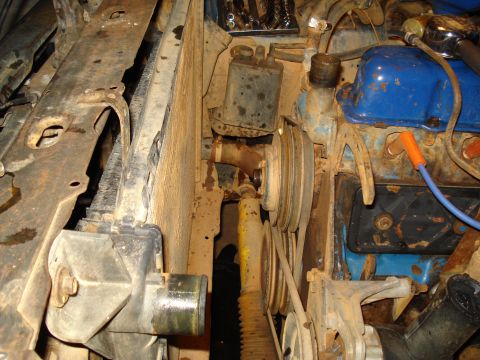 1985 Ford F-150 - This image shows various engine components, including the radiator, belts, and pulleys, in a vehicle's engine bay.