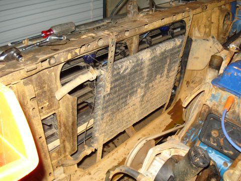 1985 Ford F-150 - Close-up view of a vehicle's radiator and surrounding engine parts, with tools visible on the frame above.