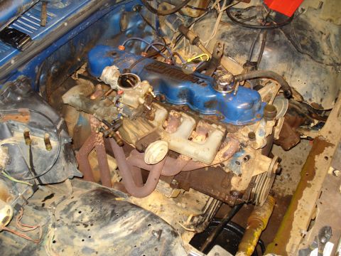 1985 Ford F-150 - Engine bay of a vehicle, showing a Ford V8 engine with blue valve covers.