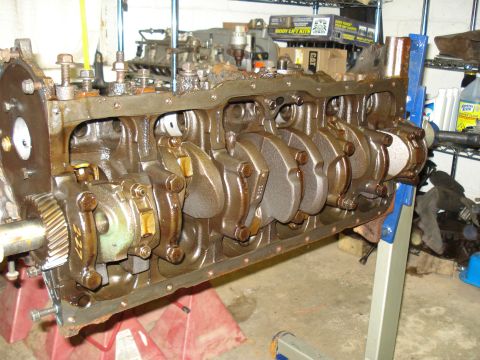 1991 Ford Bronco - Close-up view of an engine block's internal components, including the crankshaft and connecting rods, resting on an engine stand.