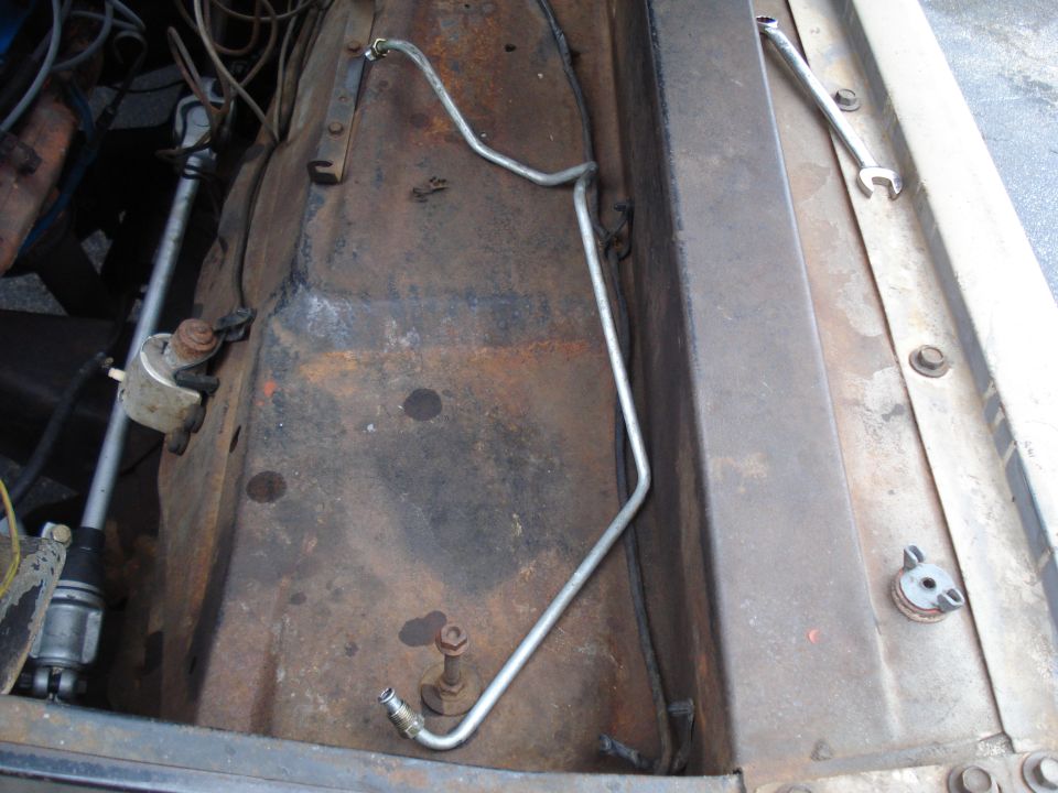 1967 Ford F-250 engine bay, rusty metal, fuel line, steering column visible