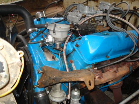 1967 Ford F-250 - The engine bay shows a blue painted engine with various hoses and wires connected.