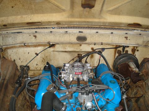 1967 Ford F-250 - Engine bay of a 1967 Ford F-250, a prominent Edelbrock carburetor and blue valve covers.