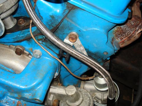 1967 Ford F-250 - Braided fuel line connected to engine component, with a small metal tag visible.