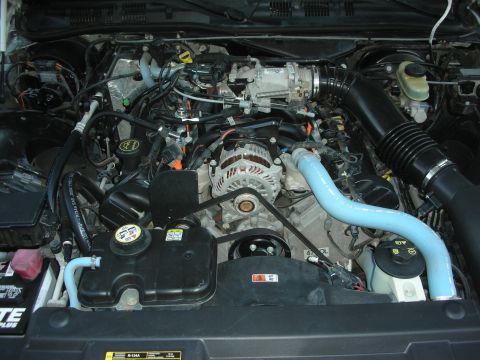 2004 Ford Crown Victoria - Close-up view of a car's engine bay, showing the intake system and other mechanical parts.