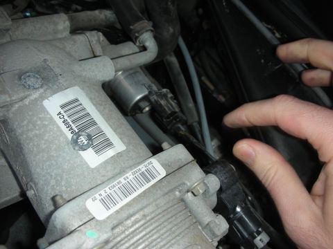 2004 Ford Crown Victoria - Close-up of engine components, including a label with a barcode and part numbers.