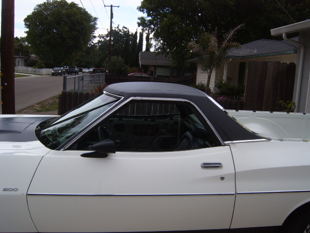 Side view of a white pickup truck with a black vinyl top. The number 500 is visible on the fender