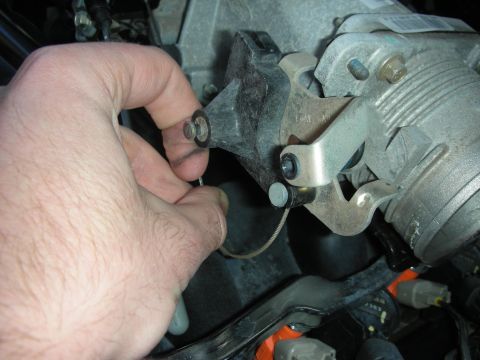 2004 Ford Crown Victoria - A hand is shown installing a throttle cable onto an engine component, likely part of an aftermarket modification.