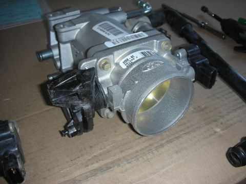 2004 Ford Crown Victoria - Close-up of a Ford throttle body assembly, likely for engine intake modification.