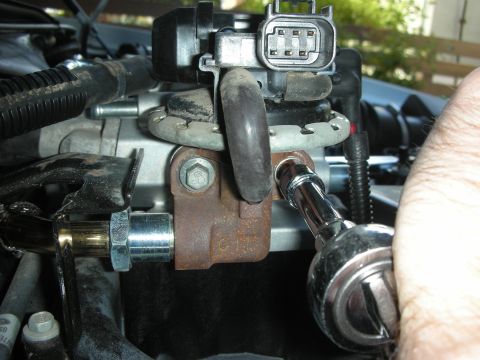2004 Ford Crown Victoria - A socket wrench is used to install or remove an engine component, likely part of an intake system modification.