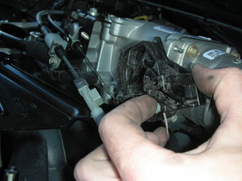 2004 Ford Crown Victoria - A hand is shown installing an engine part, with some text visible on the component.