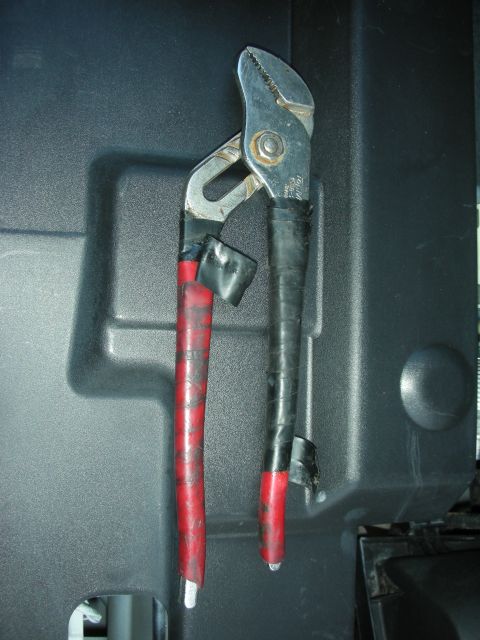2004 Ford Crown Victoria - A pair of channel lock pliers with modified handles are shown against a textured plastic background.