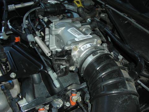 2004 Ford Crown Victoria - Close-up view of engine components, including the intake manifold and throttle body, with various hoses and wiring.