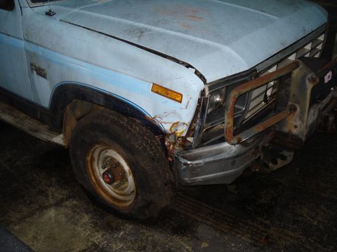 1967 Ford F-250 - The front passenger side of a light blue pickup truck shows damage to the fender and bumper area.