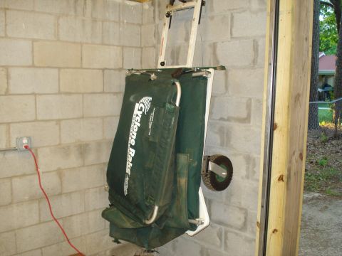 1967 Ford F-250 - Cyclone Rake leaf collection system folded and mounted on a cinder block wall.