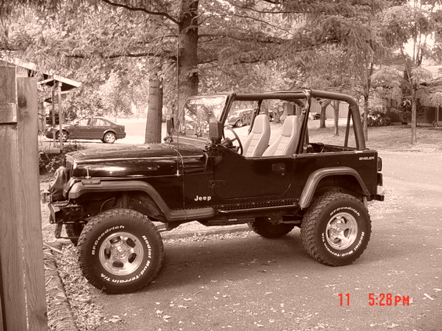 Black 1995 Jeep Wrangler side view with off-road tires