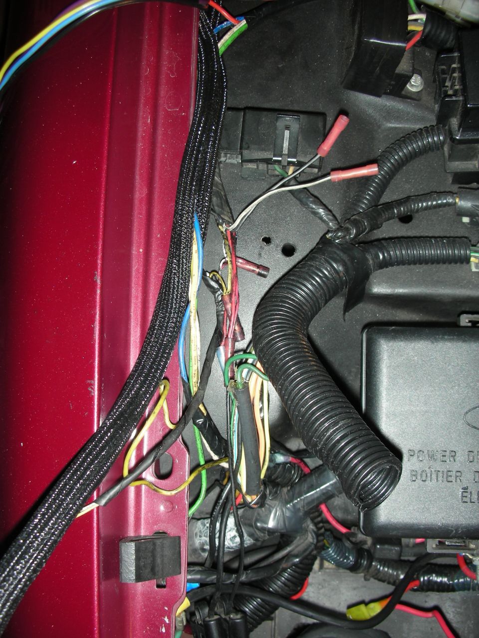 Red vehicle fender with complex wiring harness and fuse box