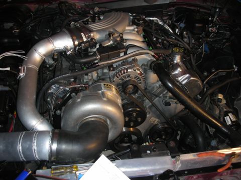 1992 Ford Crown Victoria - Close-up view of a modified engine bay a prominent supercharger and custom piping.